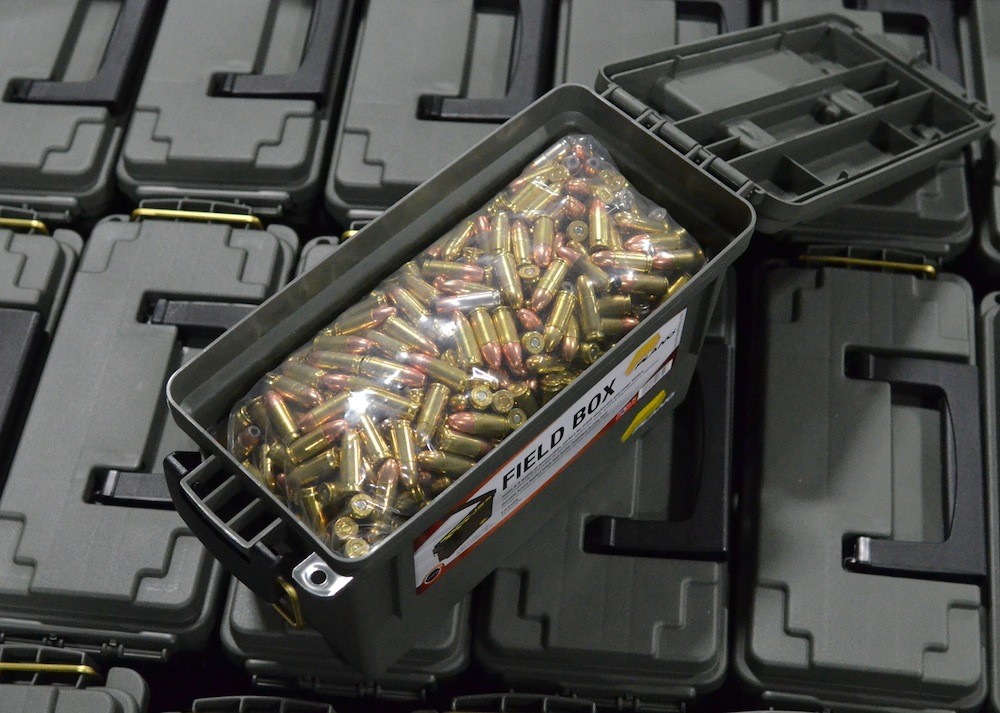 Plano ammo can filled with 9mm rounds sitting on a pallet of other cans.